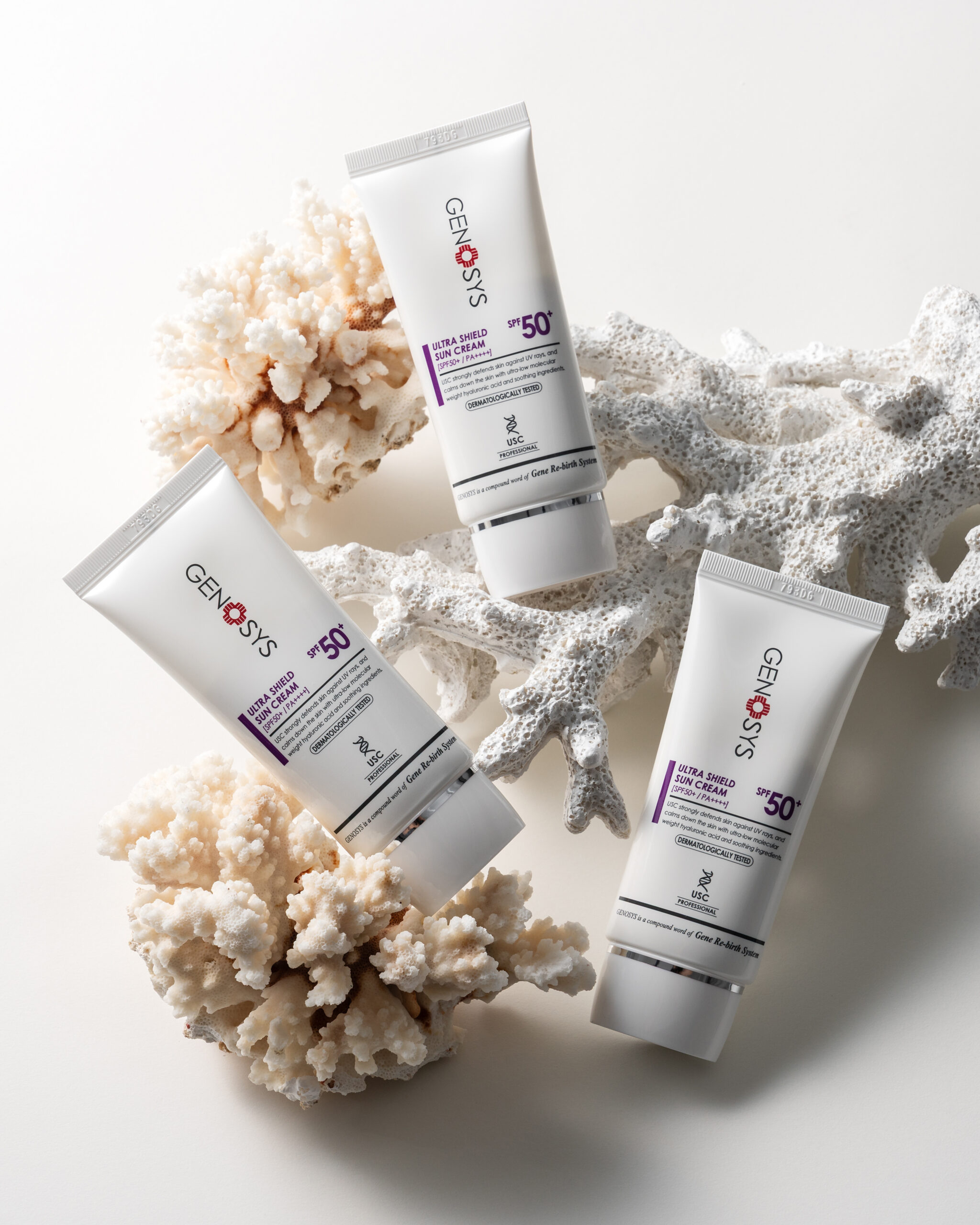 GENOSYS Ultra Shield Sun Cream SPF50 tubes styled with white coral